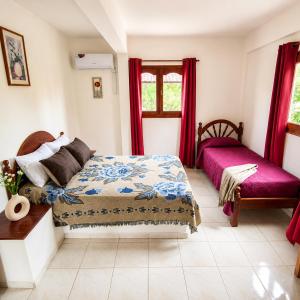 a bedroom with a bed and a window with red curtains at El Crestón Hotel in Coronel Moldes +34 photos