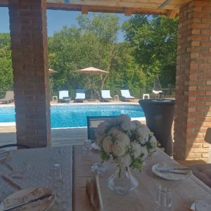 a table with a vase of flowers on a table with a pool at River House Batrovci in Batrovci