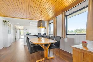 a dining room with a table and black chairs at 8599-Glesborg-Amagervej-4 in Glesborg +19 photos