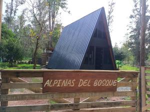 a sign with a solar roof on a wooden fence at Alpinas del bosque II in Maldonado
