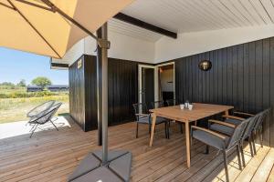 a dining room with a table and chairs on a deck at 8599-Glesborg-Amagervej-4 in Glesborg