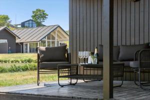 a patio with two chairs and a table with wine glasses at 8599-Glesborg-Amagervej-4 in Glesborg
