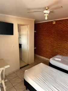 a room with a bed and a tv and a room with a bed gmaxwell gmaxwell at Pousada Saturnino in Hortolândia +7 photos