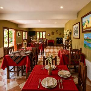 a restaurant with red tables and chairs with red tablecloths at El Crestón Hotel in Coronel Moldes