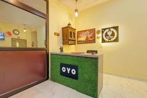 a waiting room with aoya sign on a green counter at Hotel O City View in Alīgarh