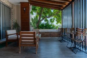 a porch with chairs and a table and a window at Karacan Hotel - Dalaman Airport in Dalaman