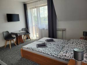 a bedroom with a bed and a desk and a window at Willa Ewelinka in Zakopane