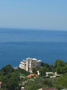 a large building on a hill next to the ocean at Apartman Alba in Petrovac na Moru