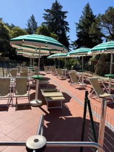 a group of chairs and tables and umbrellas at Happy Hen Garden Suite in Bivigliano