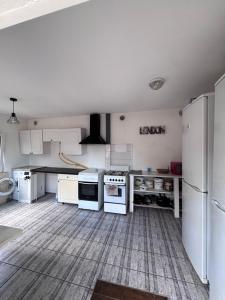 a kitchen with white appliances and a tile floor at apartamienty "Pozitiv" in Karolino-Buhaz