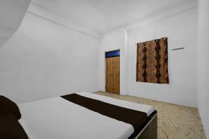 a white bedroom with a bed and a door at SPOT ON Pk Hotel & Restaurant in Meja