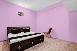 a bedroom with a bed and a chair in it at SPOT ON Pk Hotel & Restaurant in Meja