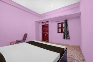 a bedroom with a bed and a chair and a window at SPOT ON Pk Hotel & Restaurant in Meja
