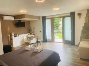 a bedroom with a bed and a kitchen and a table at Il Vigneto Rooms & Breakfast - Valtellina Panoramic View in Castione Andevenno