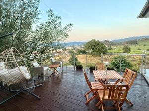 a deck with chairs and a table and a swing at Horizonte da Vinha in Santo Tirso