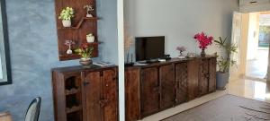 a living room with a tv and a wooden cabinet at Casa na Grande Florianopolis in Palhoça