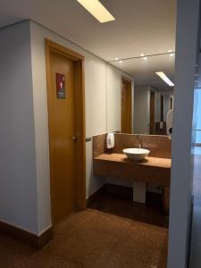 a bathroom with a sink and a mirror at Flat Hotel S4 - Aguas Claras in Brasília +16 photos