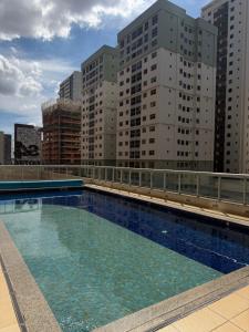 a swimming pool on the roof of a building with tall buildings at Flat Hotel S4 - Aguas Claras in Brasília