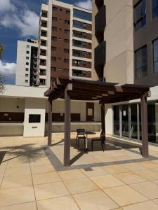 a bench under a wooden canopy in front of a building at Flat Hotel S4 - Aguas Claras in Brasília