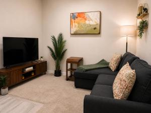 a living room with a couch and a flat screen tv at Cozy Private 1BR Basement Suite in Calgary