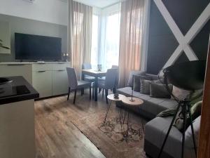 a living room with a couch and a table with chairs at Horizont 360 Gold in Vrnjačka Banja
