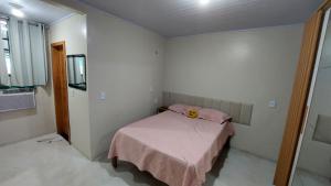 a bedroom with a bed with a pink blanket at Apartamento próximo ao Bumbódromo in Parintins