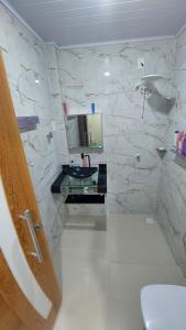 a bathroom with a sink and a mirror at Apartamento próximo ao Bumbódromo in Parintins