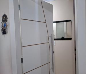 a white cabinet with a mirror in a room at Apartamento próximo ao Bumbódromo in Parintins