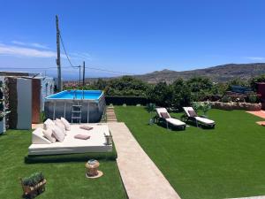a backyard with a white couch and chairs on the grass at Joha's Zen in Islas Canarias
