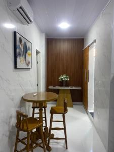 a dining room with a table and two stools at APTO - Espaço Vix II in Vitória