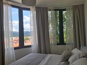 a bedroom with a bed and a large window at Horizont 360 Gold in Vrnjačka Banja