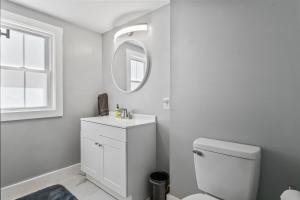 a bathroom with a white toilet and a mirror at Willard Modern Cozy Apt 1st Floor in Whitefield +16 photos