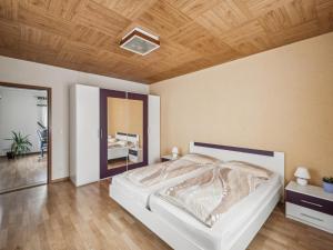 a bedroom with a white bed and a wooden ceiling at Frida in Lichtenhain