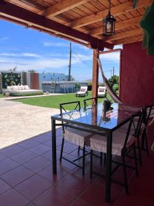 a glass table and chairs on a patio with a hammock at Joha's Zen in Islas Canarias