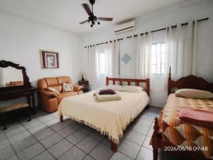 a bedroom with two beds and a couch and a fan at CASA com ACOMODAÇÃO para 6 PESSOAS in Guaratinguetá +47 photos