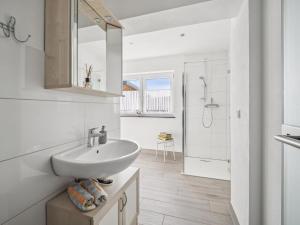 a white bathroom with a sink and a shower at Frida in Lichtenhain +13 photos