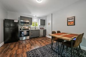 a kitchen with a wooden table and a black refrigerator at Willard Modern Cozy Apt 1st Floor in Whitefield