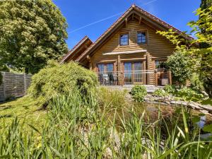 a log house with a pond in front of it at Bavaria in Teunz