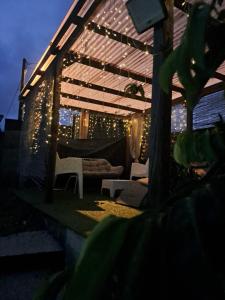 a patio with a pergola with lights on it at Le Cuprum in Le Robert