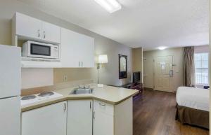 a kitchen with a sink and a microwave in a room at Extended Stay America Select Suites - Raleigh - RDU Airport in Morrisville