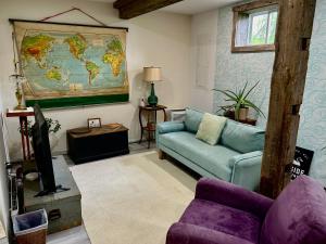 a living room with a couch and a map of the world at Oyster Shell Cottage in York
