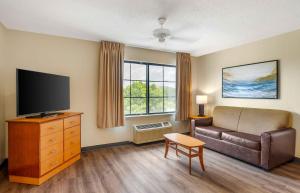 a living room with a couch and a flat screen tv at Extended Stay America Suites - Melbourne - Airport in Melbourne
