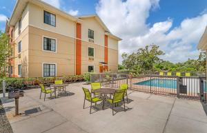a patio with tables and chairs next to a pool at Extended Stay America Suites - Melbourne - Airport in Melbourne