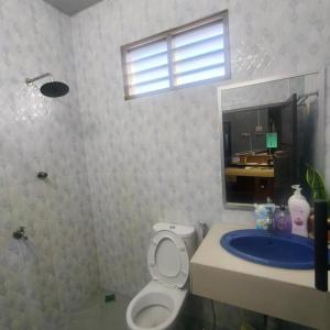 a bathroom with a toilet and a sink and a mirror at Quddus Inn villa in Wakaf Baharu +18 photos