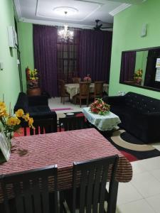 a living room with a table and a couch at Quddus Inn villa in Wakaf Baharu