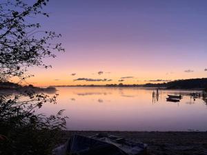 a sunset over a lake with two boats on it at 4 star holiday home in Svendborg in Svendborg