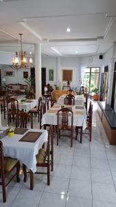 a dining room with tables and chairs and a restaurant at Pondok Ganda in Ambarita