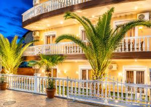 a building with palm trees in front of it at JONNY'S Rooms in Paralia Katerinis