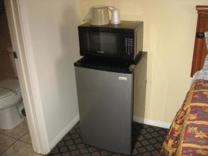 eine Mikrowelle auf einem kleinen Kühlschrank in der Unterkunft Tower Motel Long Beach in Long Beach