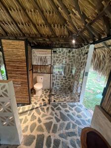 a bathroom with a toilet and a stone wall at Finca Campestre Doradal in Doradal +79 photos